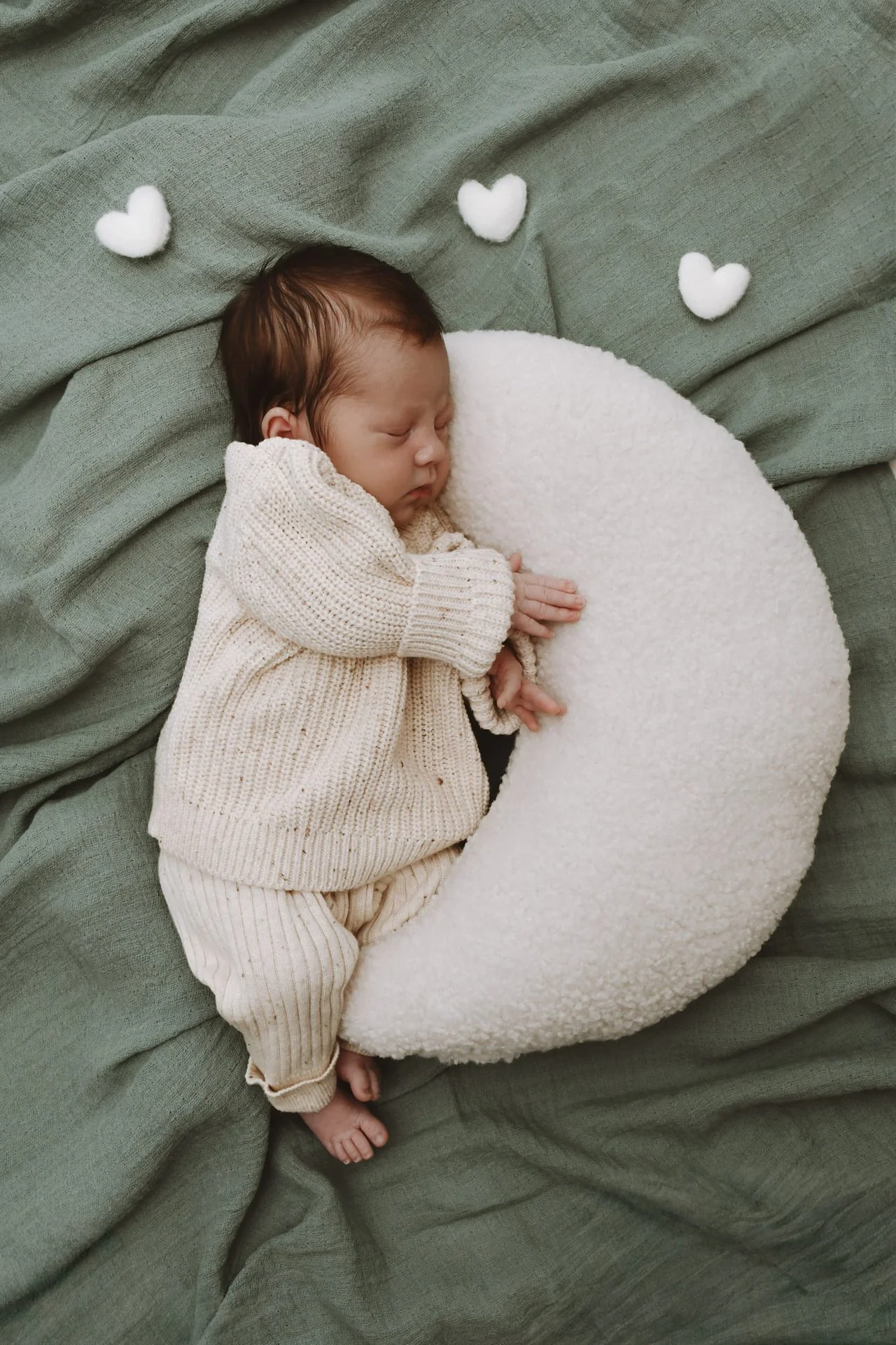 Newborn auf Halbmond mit Herzen